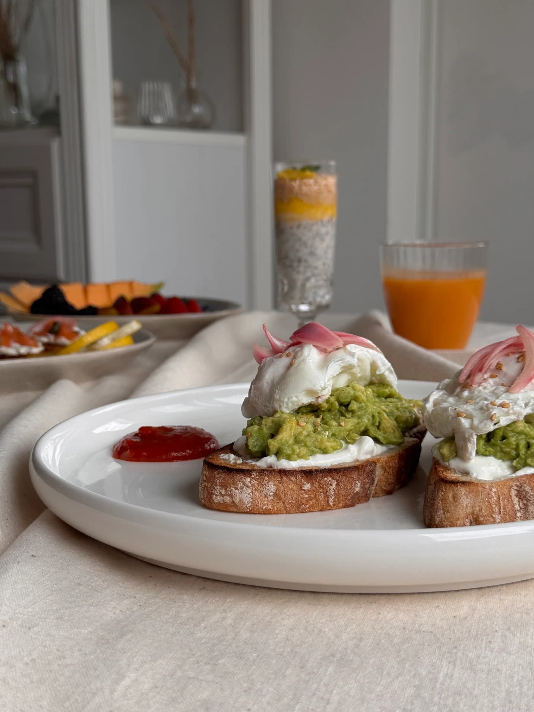 Avocado toast with poached eggs and breakfast sides